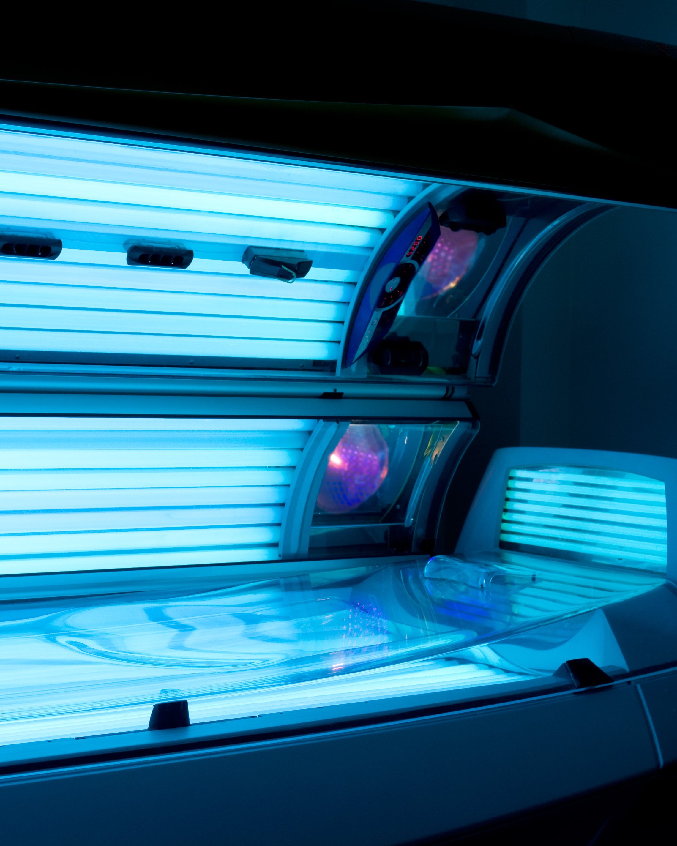 Close-up of a tanning bed with glowing blue lights